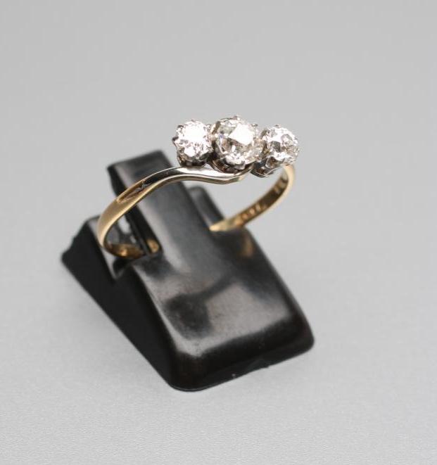 A THREE STONE DIAMOND CROSSOVER RING Image