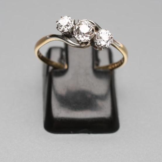 A THREE STONE DIAMOND CROSSOVER RING Image