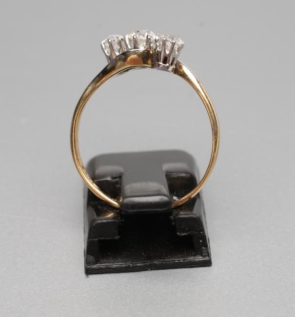A THREE STONE DIAMOND CROSSOVER RING Image