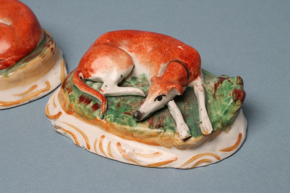 A PAIR OF STAFFORDSHIRE POTTERY GREYHOUNDS Image