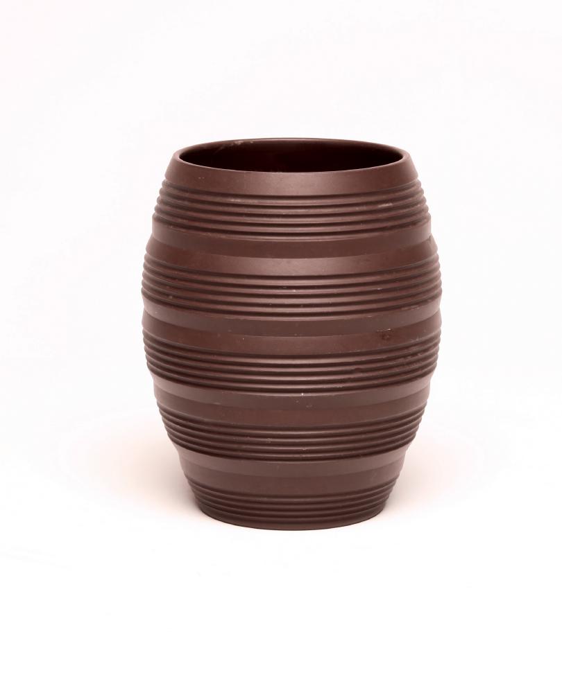 KEITH MURRAY FOR WEDGWOOD - A dark brown basalt barrel vase with five engine turned ribbed bands Image