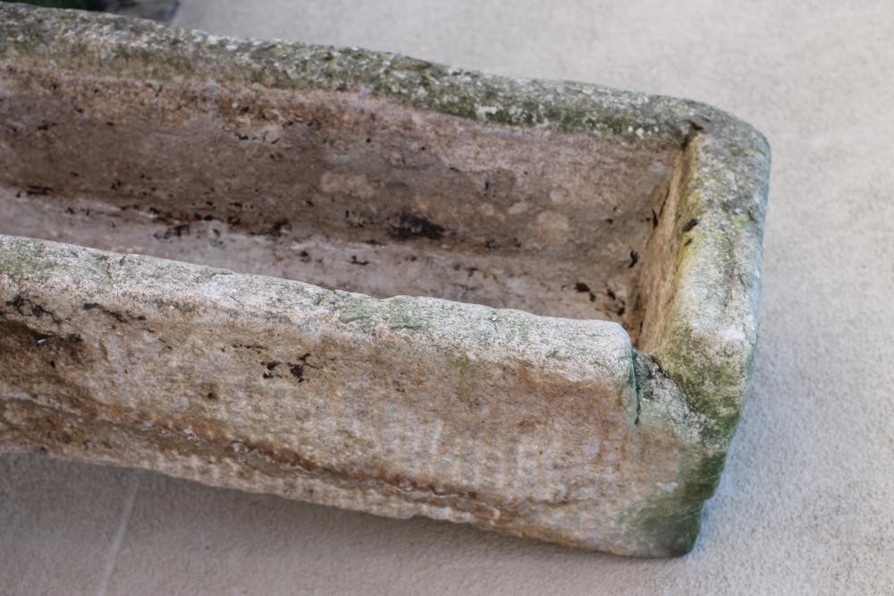 A LARGE GRANITE TROUGH of rough hewn narrow oblong form with mildly tapering sides Image