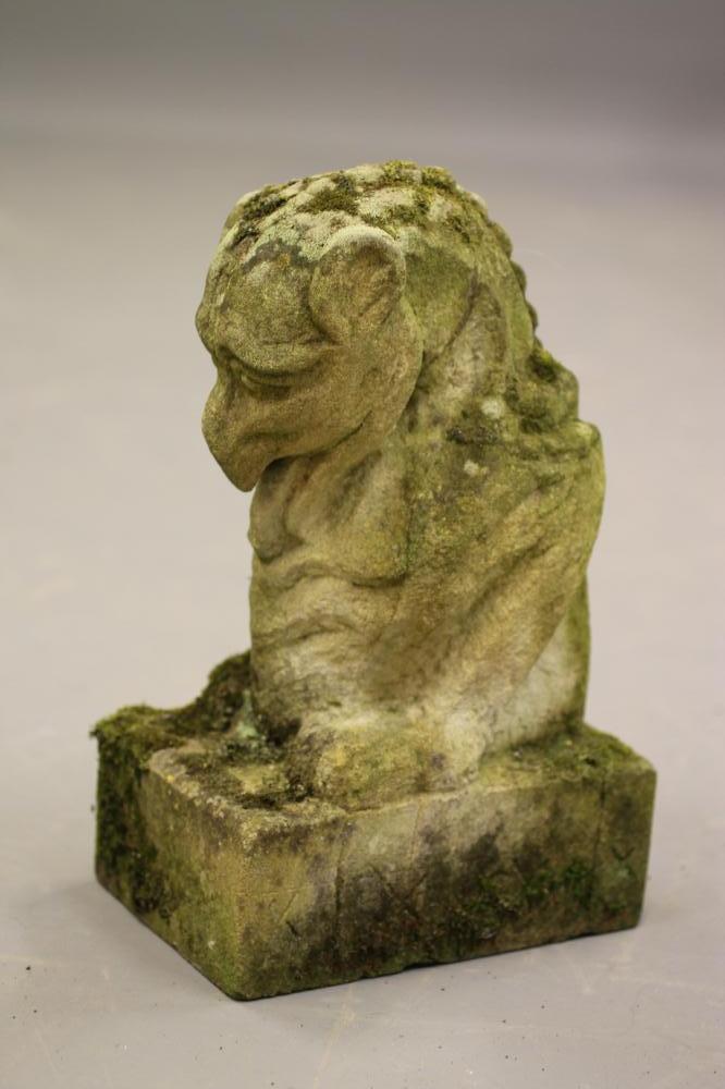 A CARVED SANDSTONE GARGOYLE modelled seated on an oblong plinth Image