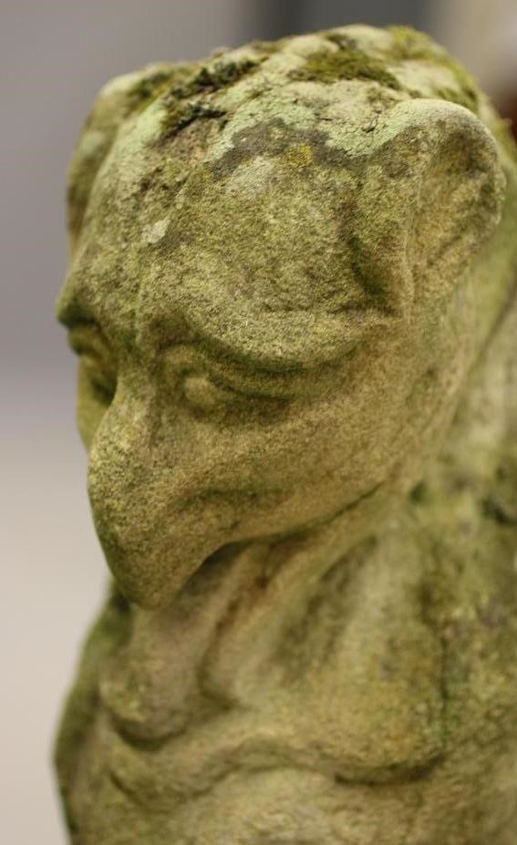 A CARVED SANDSTONE GARGOYLE modelled seated on an oblong plinth Image