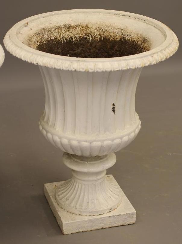 A PAIR OF VICTORIAN CAST IRON GARDEN URNS of half fluted campana form with egg and dart moulded rim Image