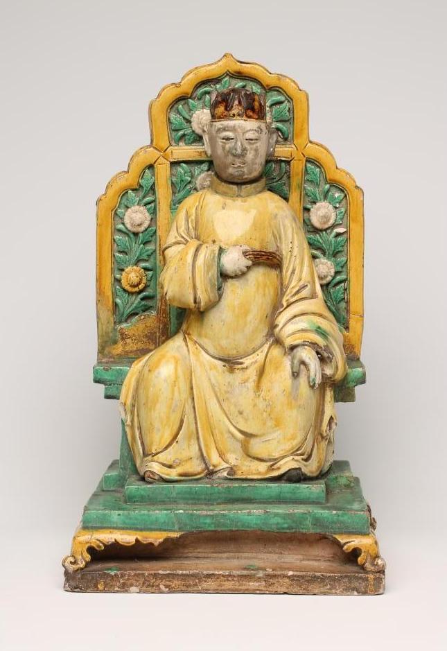 A CHINESE EARTHENWARE FIGURE modelled as a dignitary seated on a flower moulded throne on a stepped Image