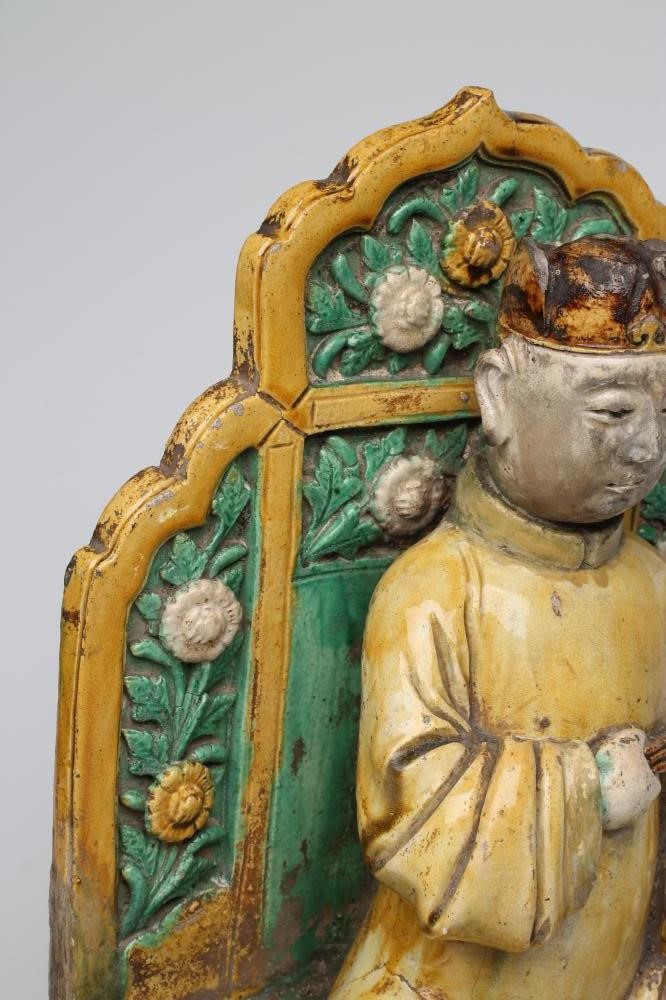 A CHINESE EARTHENWARE FIGURE modelled as a dignitary seated on a flower moulded throne on a stepped Image