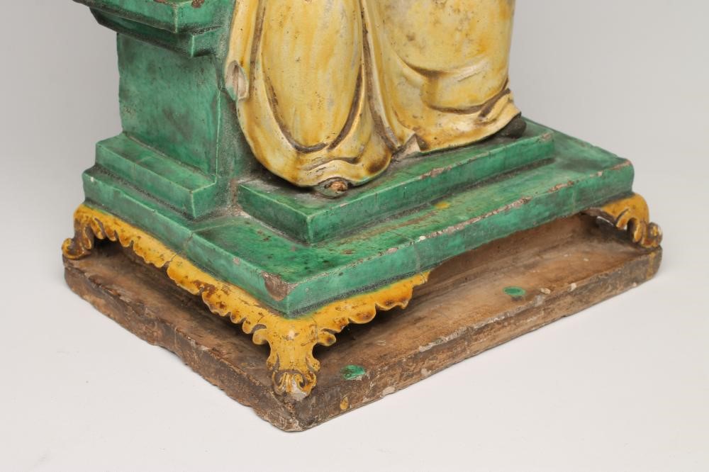 A CHINESE EARTHENWARE FIGURE modelled as a dignitary seated on a flower moulded throne on a stepped Image