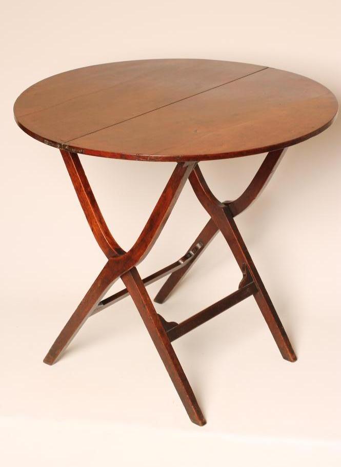 A GEORGIAN MAHOGANY FOLDING "COACHING TABLE" of circular form raised on shaped square section X Image