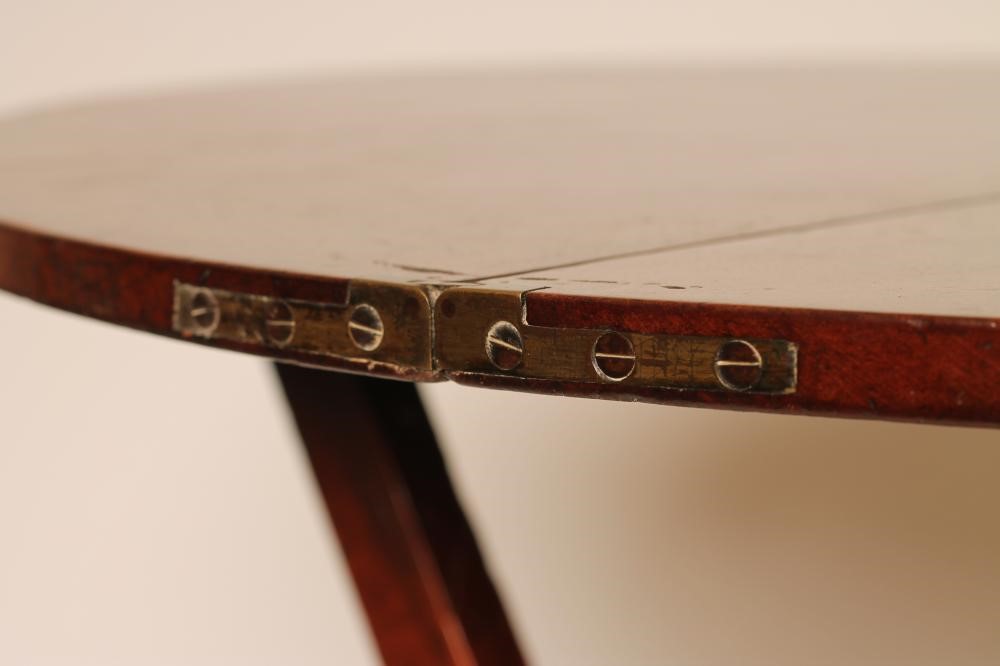 A GEORGIAN MAHOGANY FOLDING "COACHING TABLE" of circular form raised on shaped square section X Image