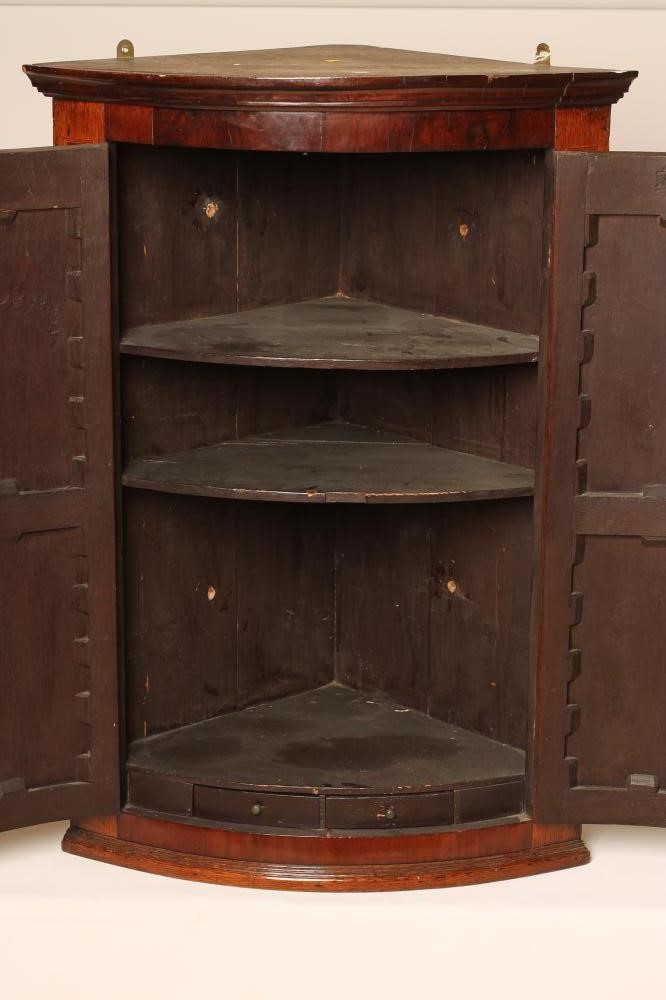 A GEORGIAN OAK AND MAHOGANY CORNER CUPBOARD Image