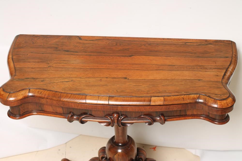 A VICTORIAN ROSEWOOD FOLDING CARD TABLE of oblong serpentine form Image
