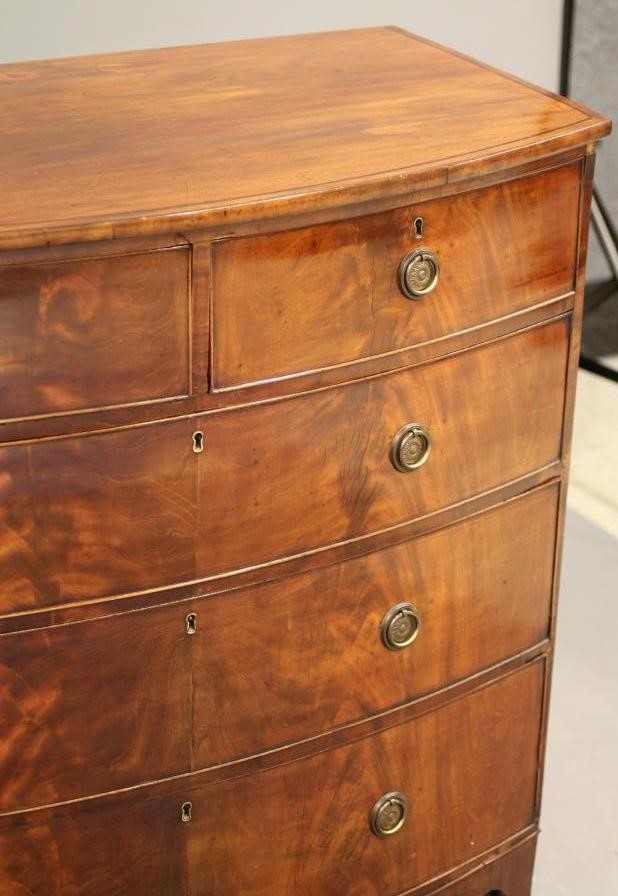 A REGENCY MAHOGANY CHEST of bowed form with ebony stringing Image