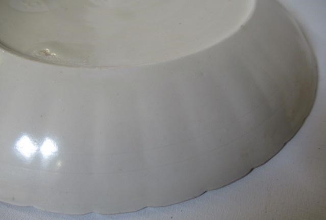A CHINESE WHITE GLAZED PORCELAIN DISH of fluted circular form centrally carved with a crane in Image