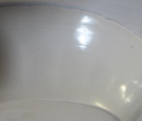 A CHINESE WHITE GLAZED PORCELAIN DISH of fluted circular form centrally carved with a crane in Image