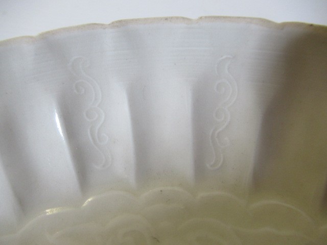 A CHINESE WHITE GLAZED PORCELAIN DISH of fluted circular form centrally carved with a crane in Image
