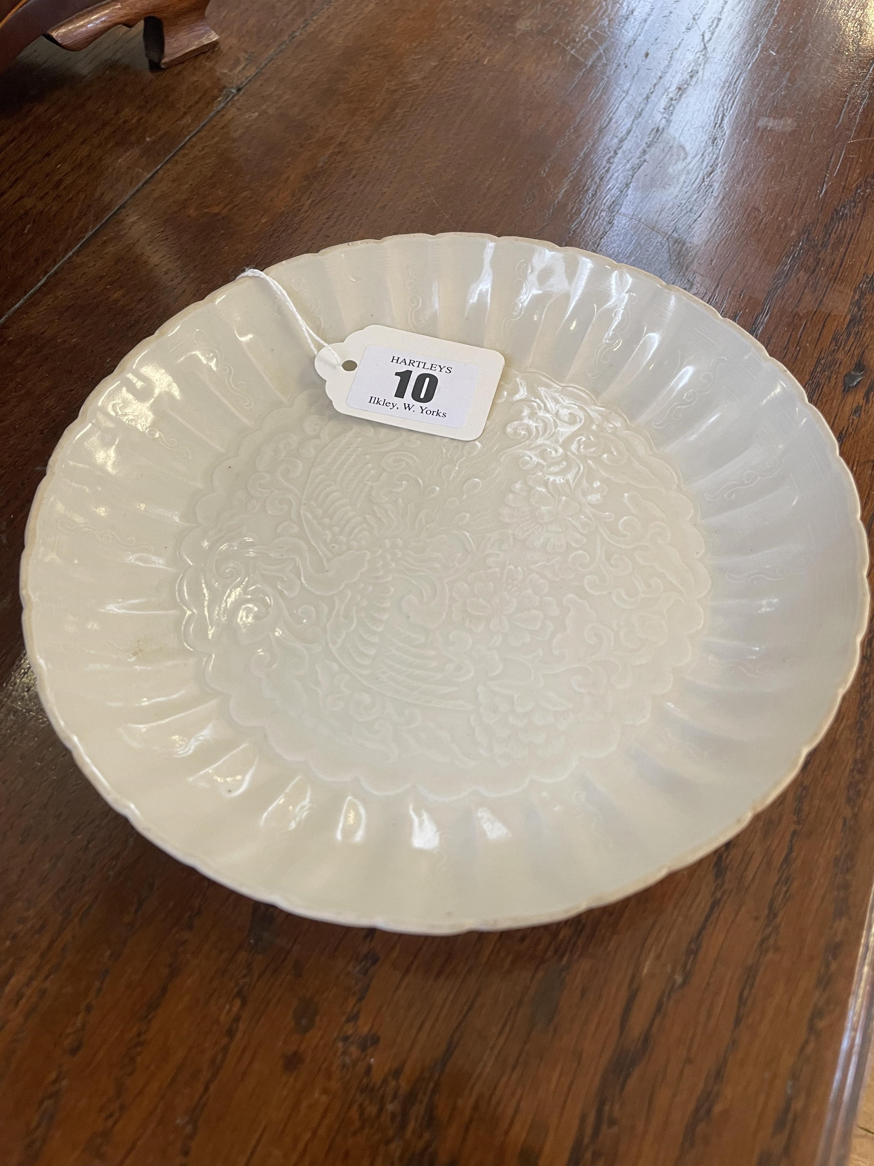 A CHINESE WHITE GLAZED PORCELAIN DISH of fluted circular form centrally carved with a crane in Image