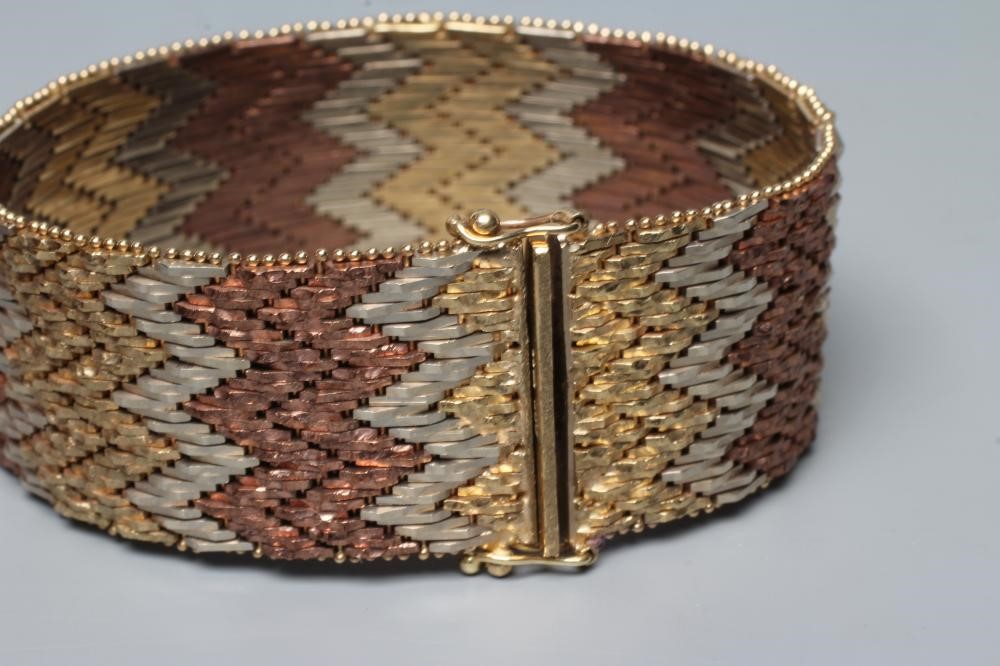 A 9CT GOLD TRI-COLOUR CUFF TO MATCH THE PREVIOUS LOT, with slide clasp, London 1978, 68.7g (Est. Image