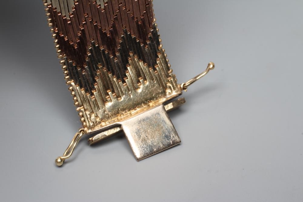 A 9CT GOLD TRI-COLOUR CUFF TO MATCH THE PREVIOUS LOT, with slide clasp, London 1978, 68.7g (Est. Image