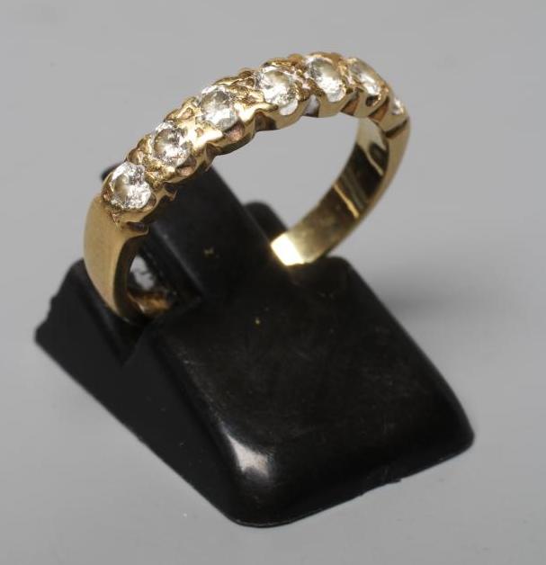 A SEVEN STONE DIAMOND HALF HOOP RING, the brilliant cut stones set to a plain 18ct gold shank, Image