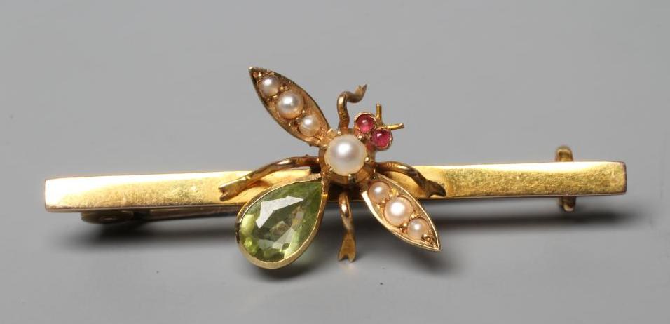 AN EDWARDIAN NOVELTY BAR BROOCH centred by an insect with seed pearl wings and head, ruby cabochon Image