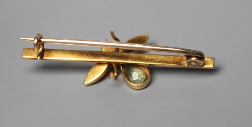 AN EDWARDIAN NOVELTY BAR BROOCH centred by an insect with seed pearl wings and head, ruby cabochon Image