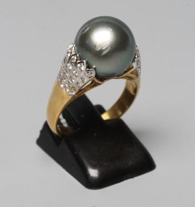 A BLACK TAHITIAN PEARL COCKTAIL RING, the pearl set within flared white shoulders set with five sets Image
