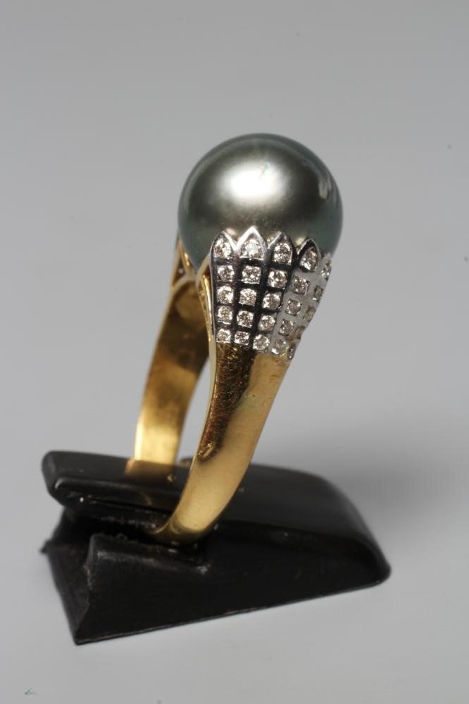 A BLACK TAHITIAN PEARL COCKTAIL RING, the pearl set within flared white shoulders set with five sets Image