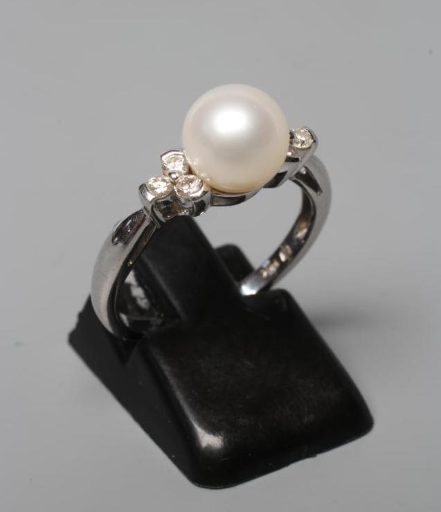 A PEARL AND DIAMOND DRESS RING, the cultured pearl peg set with three small round brilliants to each Image