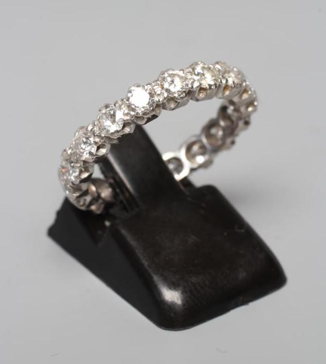 A DIAMOND ETERNITY RING, the eighteen round brilliants set to a plain unmarked white shank, size L Image