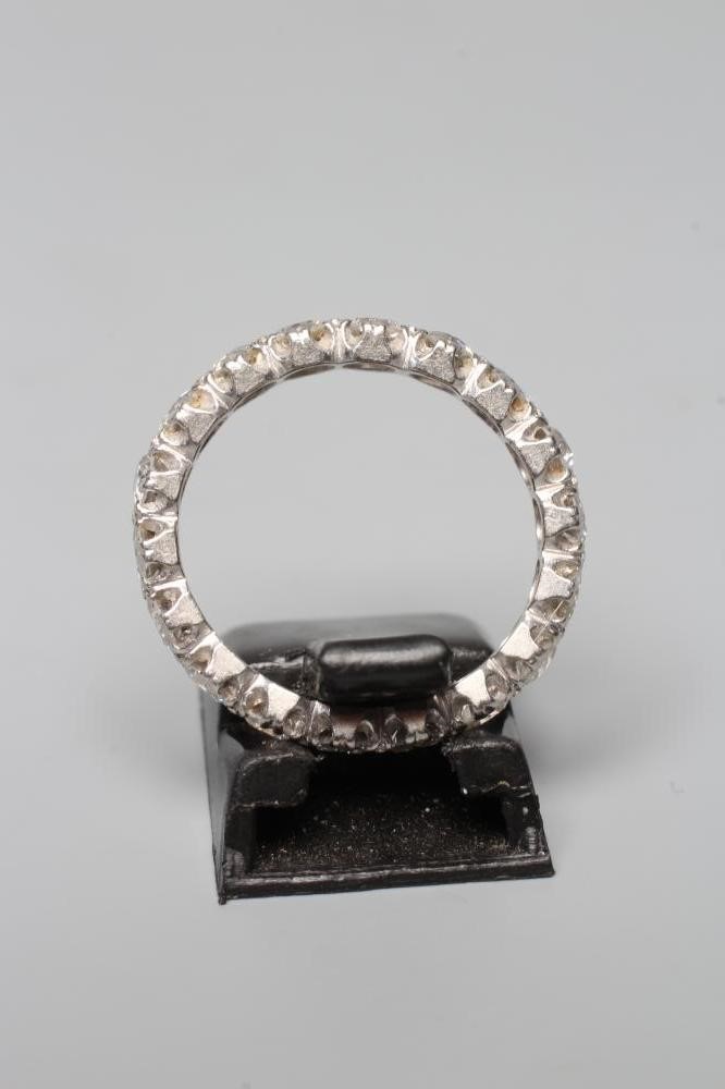 A DIAMOND ETERNITY RING, the eighteen round brilliants set to a plain unmarked white shank, size L Image