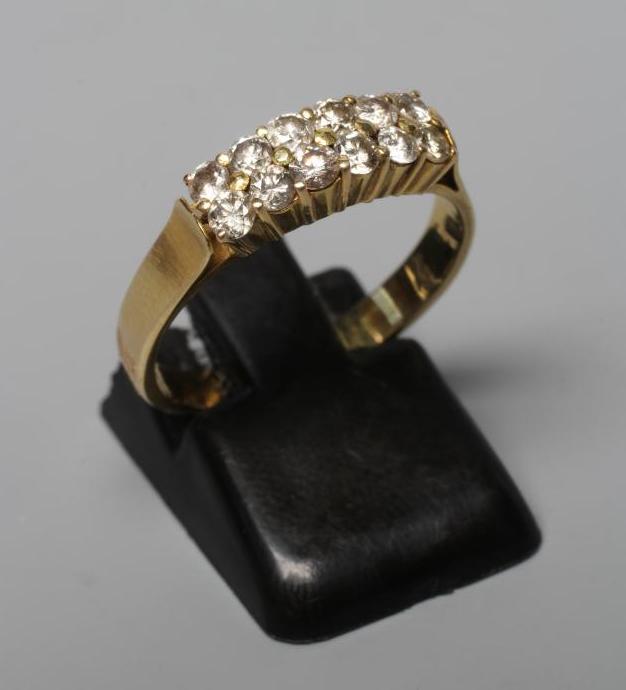 A DIAMOND RING, the six pairs of brilliants claw set to a plain unmarked shank, size O (Est. plus Image