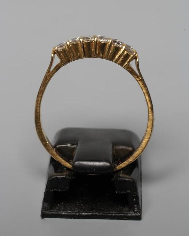 A DIAMOND RING, the six pairs of brilliants claw set to a plain unmarked shank, size O (Est. plus Image