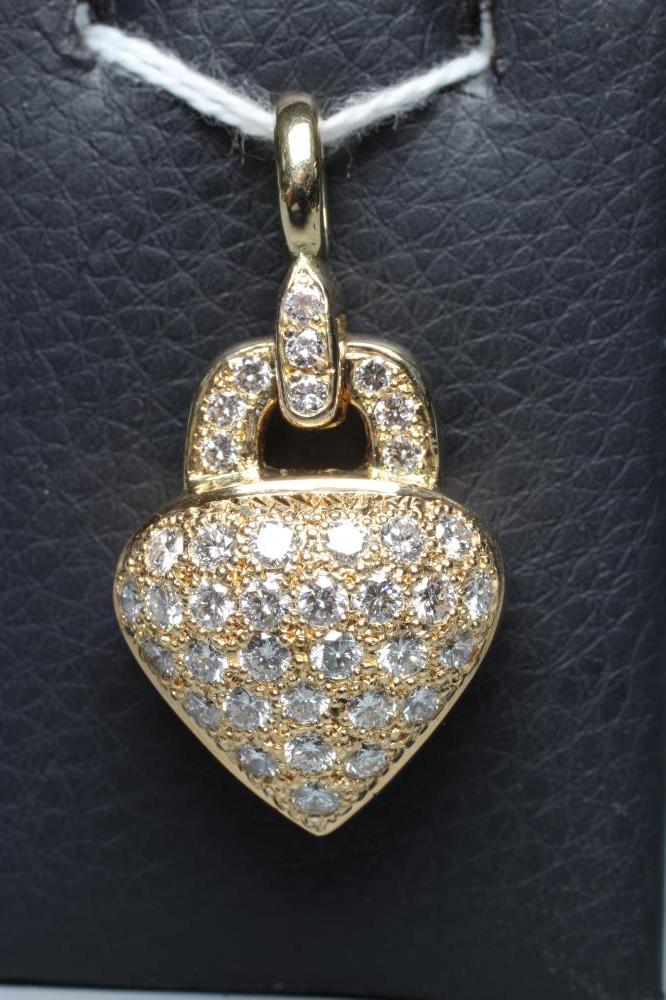A DIAMOND HEART PADLOCK PENDANT set with numerous small brilliant cut stones to a pointille ground, Image