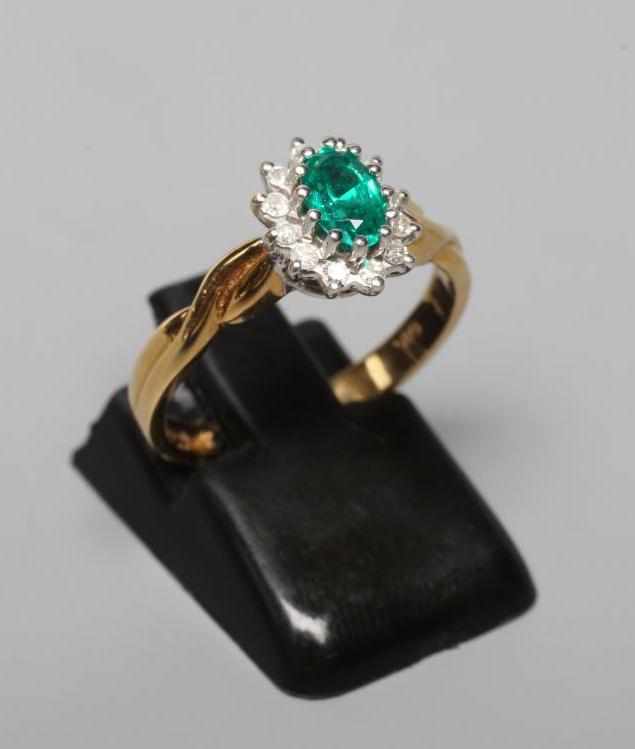 AN EMERALD AND DIAMOND CLUSTER RING Image