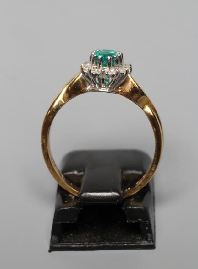 AN EMERALD AND DIAMOND CLUSTER RING Image
