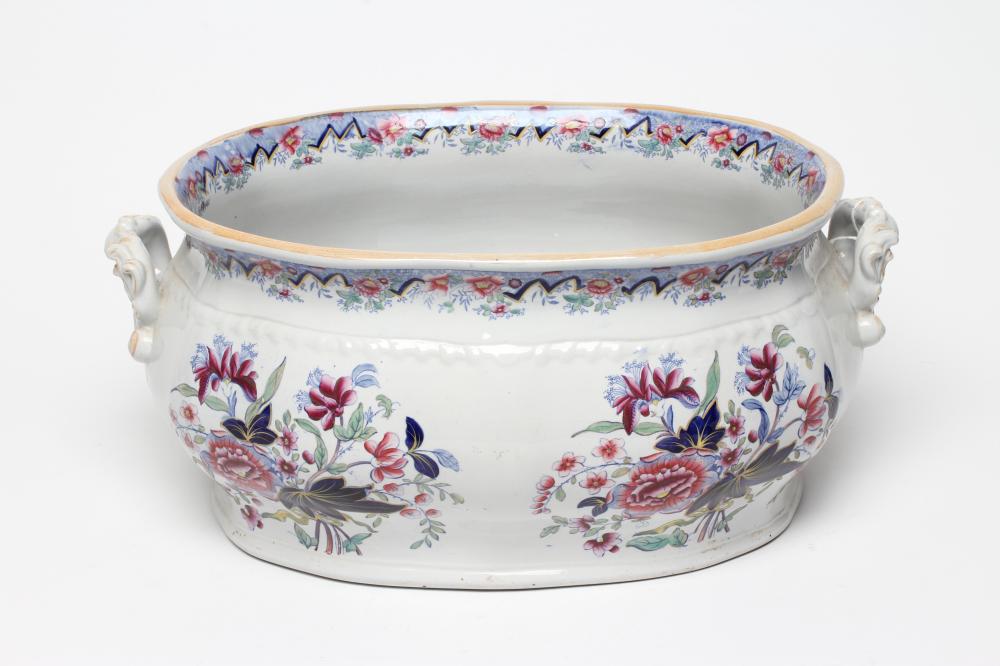 A VICTORIAN EARTHENWARE FOOTBATH of lobed bombe rounded oblong form with two scroll handles Image