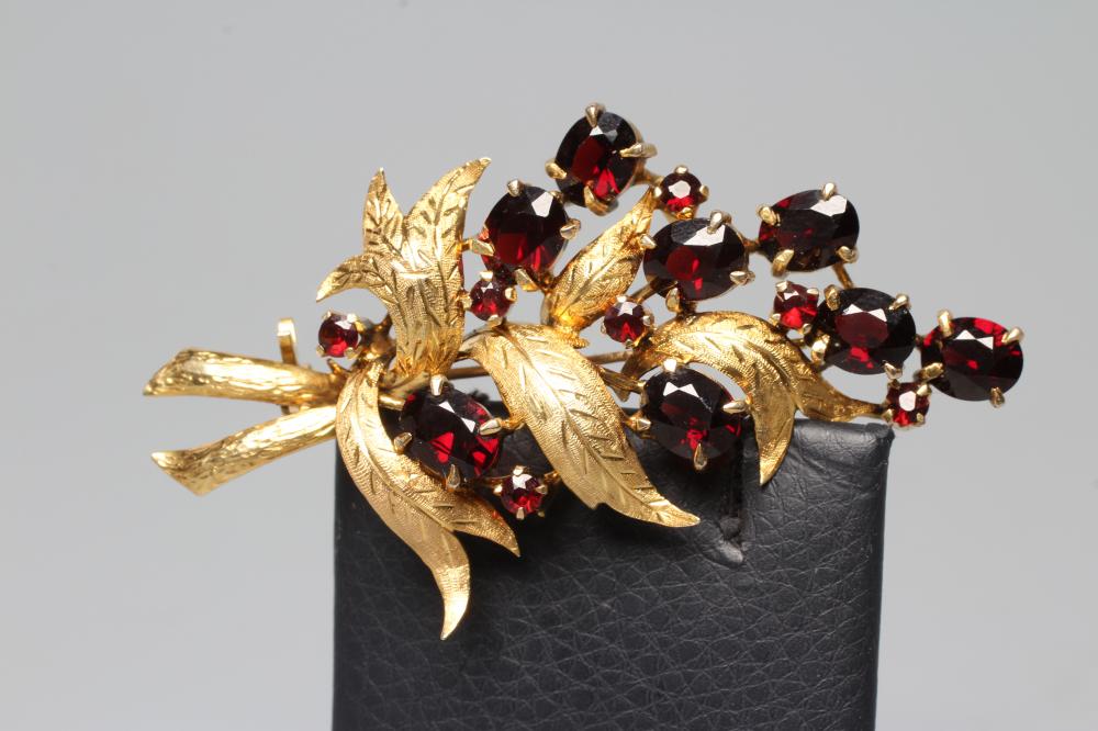 A VICTORIAN STYLE GARNET SPRAY BROOCH with fifteen various cut and sized stones claw set to a leaf Image