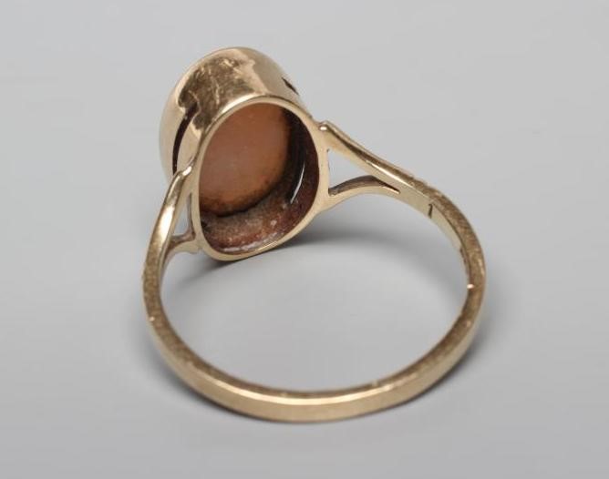 AN OPAL DRESS RING, the oval cabochon polished stone collet set to open shoulders and a plain 9ct Image