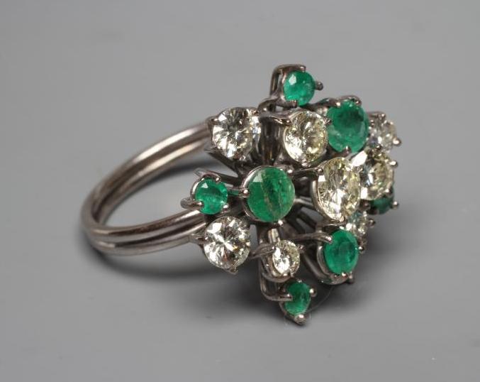 AN EMERALD AND DIAMOND COCKTAIL RING, the nine diamonds and seven emeralds of varying sizes claw set Image