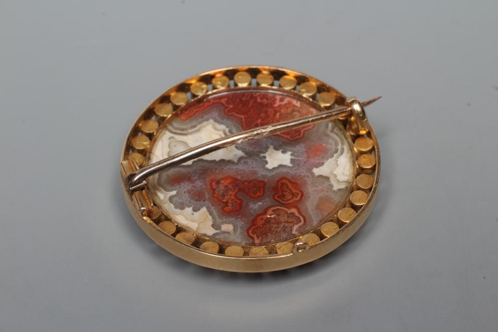 A LATE VICTORIAN BROOCH centrally set with a polished banded agate panel within an open border of Image