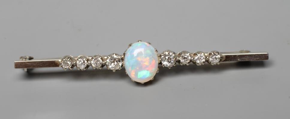 AN OPAL AND DIAMOND BAR BROOCH, the central oval cabochon polished opal claw set and with four Image