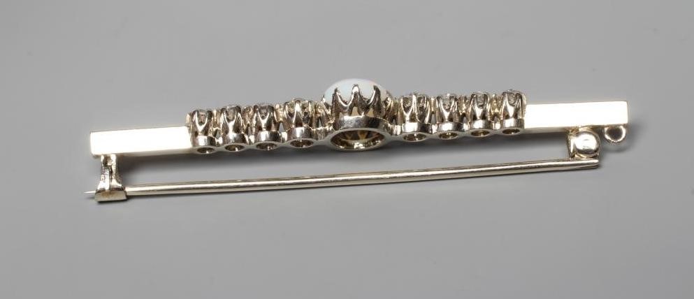 AN OPAL AND DIAMOND BAR BROOCH, the central oval cabochon polished opal claw set and with four Image