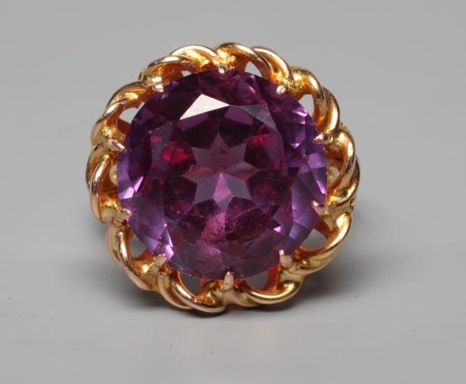 AN ALEXANDRITE DRESS RING, the circular facet cut stone claw set to a twist mount, open shoulders Image