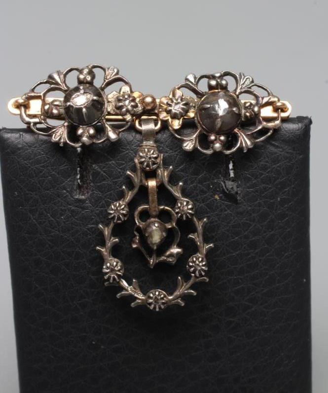 A GEORGIAN SILVER DROP BROOCH, the three open oval panels each centred by an old rose cut diamond, Image