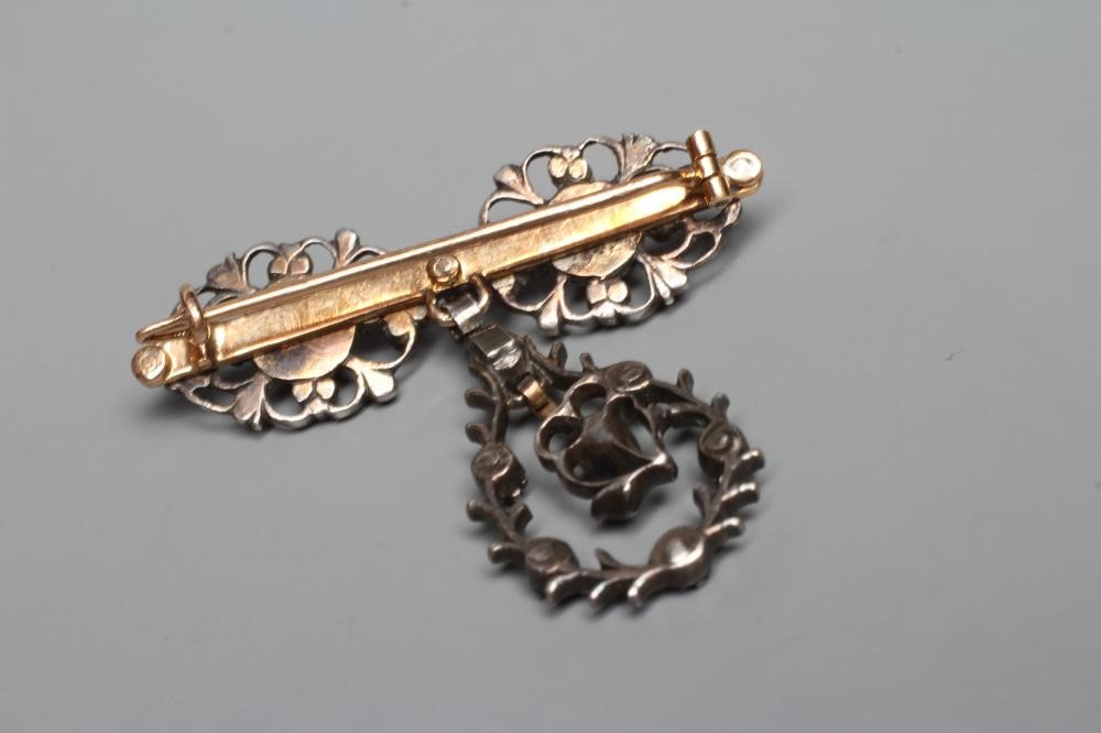 A GEORGIAN SILVER DROP BROOCH, the three open oval panels each centred by an old rose cut diamond, Image