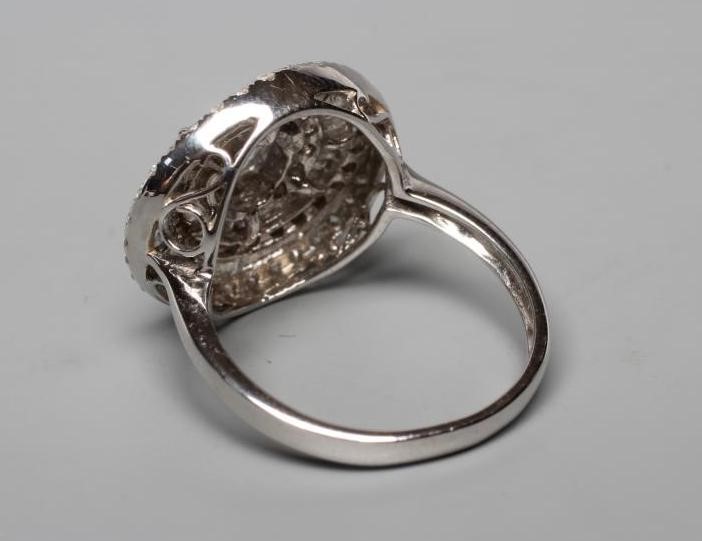 A DIAMOND COCKTAIL RING centred by three pear cut stones within a spiral of point set brilliant cut Image