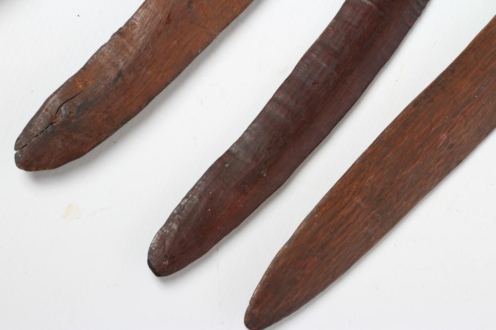 ABORIGINAL TOOLS AND WEAPONS, c.1900, comprising three Boomerangs with linear carved patination, Image