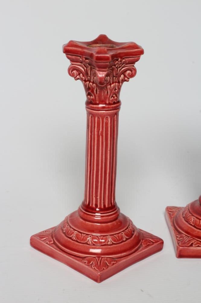 A PAIR OF BURMANTOFTS PINK GLAZED FAIENCE CORINTHIAN COLUMN CANDLESTICKS, c.1900, with fixed sconces Image