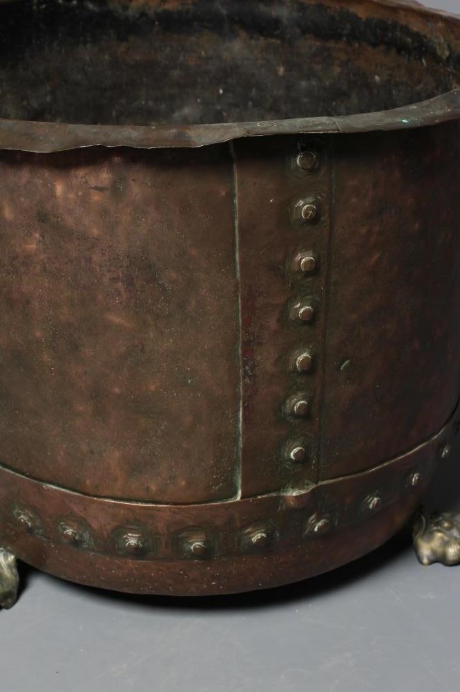 A COPPER LOG BIN, c.1900, of circular form with flared rim and riveted banding, on brass lion paw Image